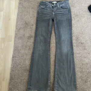 Grå bootcut jeans Gina Tricot 158 - Snygga grå jeans från Gina Tricot i storlek 158. Modellen har bootcut-ben och klassisk femficksdesign med coola detaljer på bakfickorna. Jeansen är i mjukt denimtyg och passar perfekt till en trendig vardagslook.