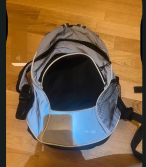 Grå och svart ryggsäck med meshficka - Snygg ryggsäck i grått och svart med praktisk meshficka på sidan och flera fack med dragkedja. Perfekt för skolan eller utflykten, med justerbara axelband och sportig look.