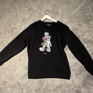 Svart sweatshirt med nalle från Closure - Svart sweatshirt från Closure London i storlek M. Använd ett par gånger. Hör av vi minsta lilla fråga.