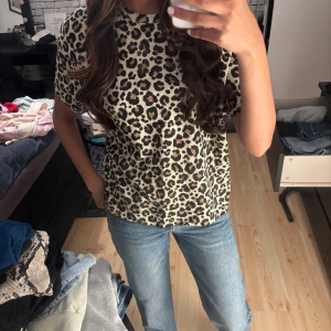 Leopardmönstrad t-shirt  - Snygg t-shirt från Zara med leopardmönster i beige, svart och brunt. Modellen är kortärmad med rund hals och har en loose fit. Använd typ 5 gånger men är som ny 