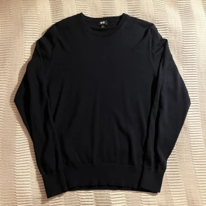 Mörkblå merino ull tröja  - En stilren mörkblå merino ull tröja från Uniqlo i storlek S. Tröjan har rund hals, långärmade och ribbade muddar vid ärmslut och nederkant. Perfekt för dig som gillar enkel och clean look med en klassisk passform. Hör av er vid minsta lilla!😃😃