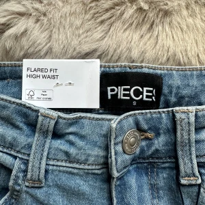 Flared jeans  - Flared, high waist jeans från Peices. Helt nya med prislappen kvar. Snygga, stretchigt material. ”PCPEGGY FLARED HW JEANS LB NOOS TALL”. Lång passform och i färgen light blue denim. 
