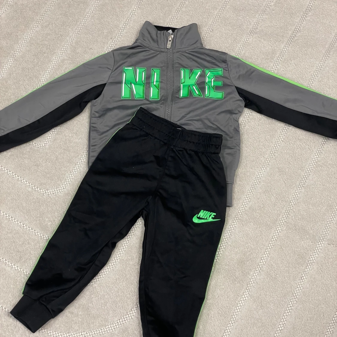 Svarta Nike mjukisbyxor med grön logga