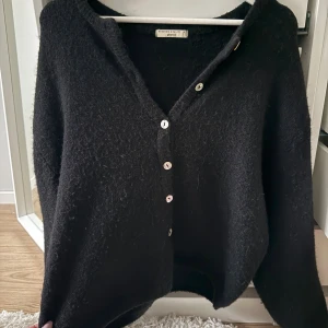 Svart kofta från Gina - Svart kofta från Gina i merinoull, storlek S.
