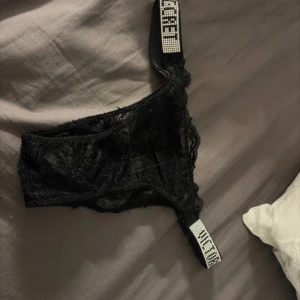 Svart spets - Supersnygga med lyxiga strassprydda band där vs -loggan syns tydligt. Bikinin är i genombruten spets som ger en exklusiv och trendig look. Perfekt för dig som vill sticka ut