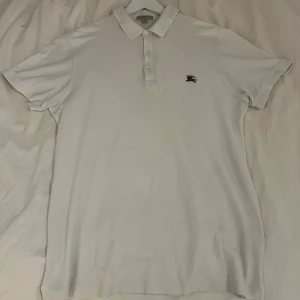 Vit Burberry piké - Som titeln lyder, piké från Burberry utan burberrys klassiska mönster vilket gör den lite mer casual. Denna är i storlek XL men skulle säga att den även passar någon som har storlek L. Den är i mycket fint skick och har inga defekter vad jag har upptäckt, förutom att den är lite skrynklig eftersom den bara legat i garderoben ett tag nu men en strykning senare så är den som ny igen. Jag tar emot bud