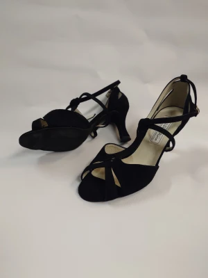 Svarta Dansskor med klack och öppen tå - Snygga svarta Dansskor från warner kern med smala remmar och öppen tå ger en elegant look, perfekt för dans eller när du vill känna dig extra dressad. Spänne vid ankeln för säker passform och stilren design. Nypris 1500-1800kr