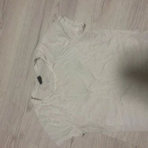 Vit t-shirt från Gina Tricot - En klassisk vit t-shirt från Gina Tricot i storlek M. T-shirten har rund hals och korta ärmar, tillverkad i mjuk bomull som är skön mot huden. Perfekt att matcha med jeans eller shorts för en enkel och clean look.