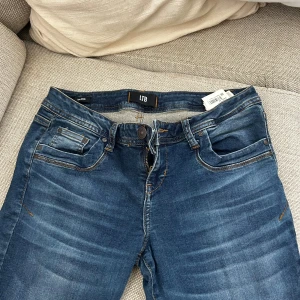 Blå jeans från LTB Valerie - Snygga blå jeans från LTB, modell Valerie. Jeansen har klassisk femficksdesign, dragkedja och knapp framtill samt kontrastsömmar. Materialet är jeans med lätt tvättad effekt och raka ben. Perfekta för en avslappnad och trendig look.