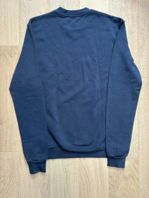 Mörkblå sweatshirt från Jacob Cohën - Snygg mörkblå sweatshirt från Jacob Cohën med diagonal logotyp i blått och vitt på framsidan. Nypris de denna ligger på 4000kr vårt pris är 999kr!!!