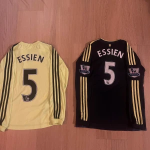 2 st äkta Michael essien longsleeve Chelsea fotbollströjor! - Säljer 2 st äkta Michael essien longsleeve Chelsea fotbollströjor! Tror båda är i storlek 152 (ungefär 12 år)! Lite svårt att se! Dem är i fint skick men den gula tröjan är lite fläckig!  Hör av dig vid minsta lilla fundering och kolla gärna in mina andra artiklar