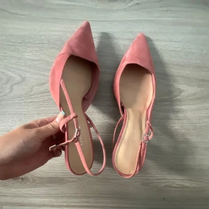 Rosa kittenheels - Snygga ballerinaskor i ljusrosa mocka med spetsig tå och smal rem runt hälen. Skorna har en elegant och feminin design som passar perfekt till både jeans och klänning. Platt sula för bekväm användning hela dagen. Mycket bra skick. Från Zara. Storlek 38