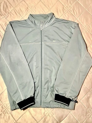 Unik Nike träningsjacka 2000s - Sällsynt vintage Nike-träningsjacka i mjuk ljusblå färg från 2000-talet. Perfekt skick. Storlek M passar som unisex.