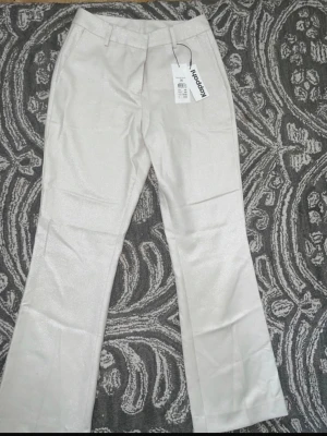 Glittriga vita kostymbyxor Kappahl - Helt nya vit/beigea glittriga utsvängda kostymbyxor! Byxorna är från Kappahl och är köpta för 499kr. Passformen är highwaist/midwaist (bryr lite på kroppstyp). Säljs då dem inte kommit till någon användning  Skriv privat vid intresse 🥰