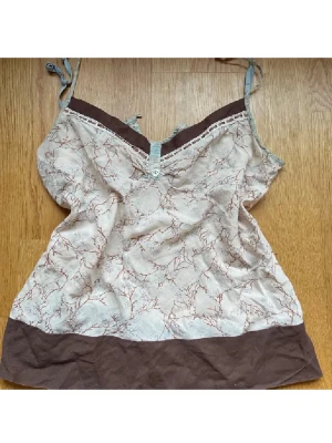 Linne med mönster  - Säljer en söt linnetopp i beige med brunt grenmönster och bred brun kant nedtill. Storlek S/M🙏