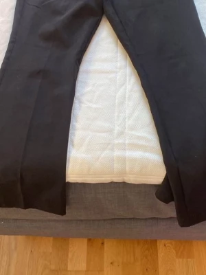 Svarta kostymbyxor med dragkedja - Svarta kostymbyxor från bikbok, de är low waist och bootcut. Perfekt för vardags eller utekväll. Osäker på storlek men allt från S till M. Har bara andvänd 2 ggr.