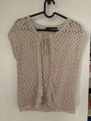 Beige stickad kofta från 157🫶🏻 - Säljer en beige stickad kofta från 157 i storlek S. Koftan har korta ärmar, öppet hålmönster och fina volangdetaljer längs kanterna. Den knyts framtill med en snörning och är perfekt för lager-på-lager. Superfin till både jeans och kjol!🤍