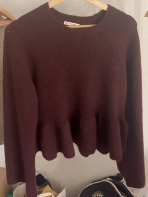 Vinröd stickad tröja med volang - Säljer en vinröd stickad tröja från Gina Tricot med volangdetalj nedtill. Endast använd en gång. Som ny! Nypris 330