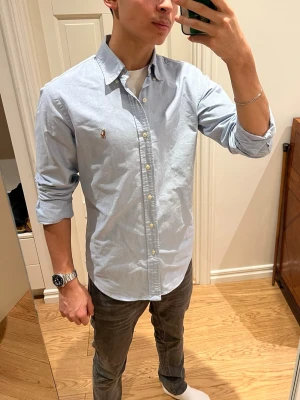 Ljusblå skjorta från Ralph Lauren - Snygg ljusblå skjorta från Ralph Lauren med klassisk krage och broderad logga på bröstet. Inga defekter. Skriv gärna om du har frågor🙌