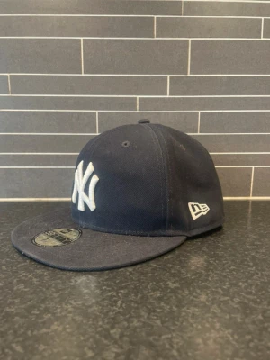 Svart New era keps - Säljer nu denna väldigt snygga New Era kepsen. Den är i storlek 7 1/8. Använt skick men inga hål eller slitningar. Priset kan gå att diskutera vid snabb affär! Hör av dig vid funderingar✅🤩