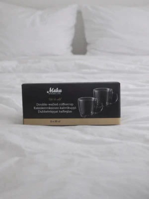 2-Pack nya Maku kaffekoppar i glas – Dubbelvägg (25cl) - Säljer ett 2-pack helt nya Maku kaffekoppar i dubbelväggat glas, fortfarande i originalförpackning. Elegant och modern design som passar perfekt för kaffe, cappuccino, latte eller te. Den smarta dubbelväggiga konstruktionen isolerar värmen, vilket gör att kopparna inte blir heta att hålla i. Perfekta både till vardags och när du vill duka lite extra snyggt. Perfekt present eller ett stilrent tillskott till det egna köket. Nypris 199kr! FÖRST TILL KVARN!