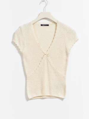 Krämvit omlottopp med rosett - Supersöt krämvit omlottopp från Gina Tricot med korta ärmar och liten rosettdetalj framtill. Toppen är stickad i ett mjukt material och har v-ringning samt ribbade kanter. Perfekt för en trendig och avslappnad look. Denna säljs inte längre och nypris är 300kr!! Helt som ny!!