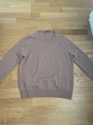 Beige kashmirtröja med rund hals - Mjuk och stilren beige tröja i kashmir med rund halsringning och ribbade muddar. Perfekt för dig som gillar en enkel och klassisk look. Långärmad modell som passar till det mesta. Köptes för 1599 kr