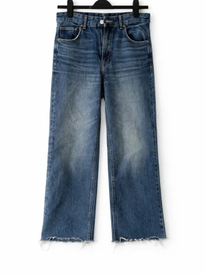 Blå raka jeans med rå kant - Ett par blå jeans med rak passform och rå, fransig kant nedtill. Jeansen har klassisk femficksdesign och en något tvättad look med ljusare partier på låren. Perfekta för en avslappnad och trendig stil.
