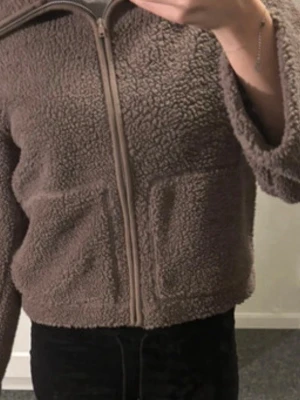 Brun teddyjacka från 157 - Mysig brun teddyjacka från 157 med dragkedja framtill och två fickor. Perfekt för kyliga dagar och har en skön, oversized känsla. Jackan är i fluffigt teddy-material och passar till många olika outfits. Pris kan diskuteras 