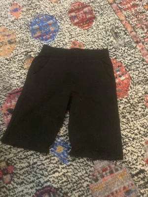 Svarta shorts med fickor - Svarta shorts med enkel design och två sidofickor. De har en rak passform och är perfekta för en avslappnad stil. Materialet känns mjukt och bekvämt, vilket gör dem sköna att bära under varmare dagar.