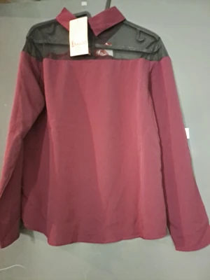 Skjorta med meshdetalj och krage - Säljer en skjorta med meshdetalj över axlarna och klassisk krage. Finns i både vinröd och svart. Skjortan har lång ärm och en stilren look som sticker ut med transparent mesh upptill. Perfekt för dig som vill ha något unikt i garderoben.