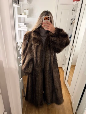 Päls kappa - Klassisk, elegant, lång äkta sjubbpäls i färgen brun och beige! Super glamorös för en kväll ute på stan. Yttligare frågor går att ställas privat
