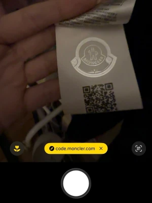 Svart dunjacka från Moncler - Snygg svart dunjacka från Moncler med klassisk logotyp på insidan och röd-blått band. Jackan har en glansig finish och är perfekt för kyliga dagar. Stilsäker och tidlös design som passar till många outfits. 