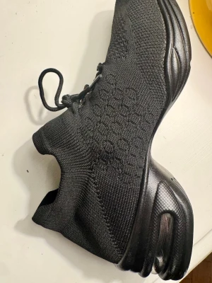 Dansskor  - Svarta dansskor för latin och jazz med stickad ovandel.  Skon har snörning, mönstrad textil och en bra "snurryta" undertill. 