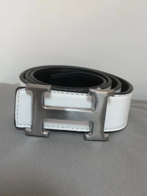 Hermes bälte (helt nytt) - Säljer detta sprillans nya Hermes bältet i vit färg, det går även att vända på spännet till svart sida om du skulle vilja det! Kontakta mig via funderingar.