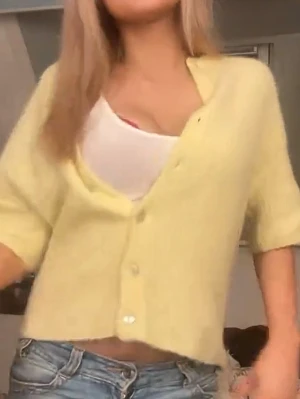 Gul kortärmad kofta med knappar - Söt ljusgul kofta med korta ärmar och pärlemorknappar framtill. Koftan har en mjuk, fluffig struktur och är något croppad i modellen. Perfekt att bära över ett linne eller t-shirt för en avslappnad look! Pris kan diskuteras 💛💛