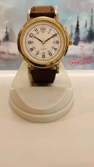 Retro Q&Q Armbandsur  - Klassisk Q&Q armbandsur med quartz urverk. Klockan har en guldfärgad boett och ett brunt läderarmband. Perfekt för den som söker en stilren och pålitlig klocka.Rustad med nytt batteri, säljes i befintligt fungerande skick, enligt bilderna