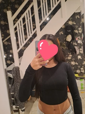 Svart croppad långärmad topp H&M - En svart, croppad långärmad topp från H&M. Enkel och stilren design med rund halsringning och tight passform. Perfekt att matcha med höga jeans eller kjol. Tillverkad i mjuk bomull för en bekväm känsla.