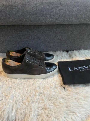 Lanvin skor - Hej, säljer nu dessa Lanvin skor. Riktigt snygga! Vid köp tillkommer orginal dustbag. Storlek 10 vilket motsvarar 44. Garanterad äkthet. Undersula i mycket bra skick (bild 4). Finns tydliga tecken på användning, se bilder. Skulle du ha en fråga får du gärna höra av dig!