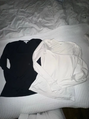 Svart och vit långärmad topp H&M XS - Två stilrena långärmade toppar från H&M i storlek XS, en svart och en vit. Tröjorna har fyrkantig urringning och är gjorda i mjuk bomull.  Tröjorna är använda enstaka gånger. Inga defekter att annmärka.  
