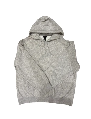 H&M hoodie loose fit - Säljer en grå hoodie från H&M i loose fit. Tröjan har huva med snörning och ribbade muddar vid ärmslut och nederkant. Perfekt för chill dagar och enkel att matcha med jeans eller joggers.