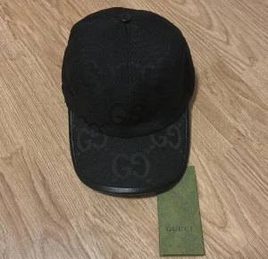 GG Jumbo keps  - Snygg GG Jumbo keps med det klassiska GG-monogrammet ton-i-ton över hela kepsen. Kepsen har böjd skärm och är tillverkad i slitstark textil med detaljer i svart. Perfekt för dig som gillar exklusiva streetwear-accessoarer.