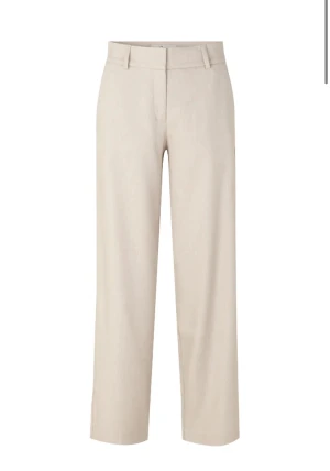 Beige linnebyxor med raka ben - Snygga beige linnebyxor med raka ben och klassisk midja. Byxorna har hällor för bälte, diskreta fickor bak och en stilren look som passar perfekt till en chill och clean outfit. Materialet är linne som ger en skön och luftig känsla. Märkes byxor 