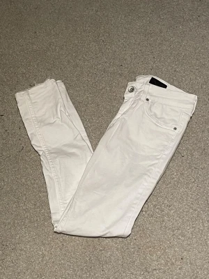 Vita jeans från Tiger of Sweden - Säljer ett par vita jeans från Tiger of Sweden. De har klassisk femficksdesign, råa kanter vid benslut och en snygg,. Perfekta om du vill ha ett par stilrena jeans med modern vibe. Materialet är mjukt och stretchigt för extra komfort.