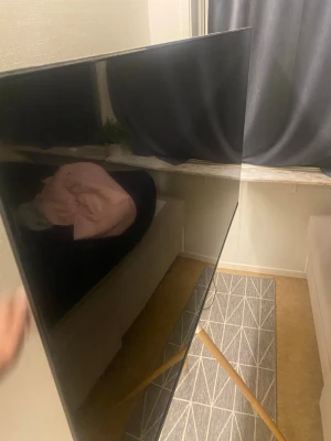 Andersson LED6546UHDA 65" LED-TV - Stor 65-tums LED-TV från Andersson, modell LED6546UHDA. Skärmen är tunn och modern, med HDMI-anslutning och UHD-upplösning. TV:n ser ut att vara i gott skick utan synliga skador eller repor. Perfekt för filmkvällar och gaming. Samt kommer ett justerbart stativ 