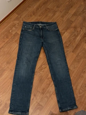 Blå Regular/Clark jeans 31/32 - Säljer ett par klassiska blå jeans i modellen Regular/Clark. Använda max 3 gånger, köpte ett par andra och gillade inte dessa så mycket. Nypris 999kr, mitt pris 599. Pris går att diskutera!!