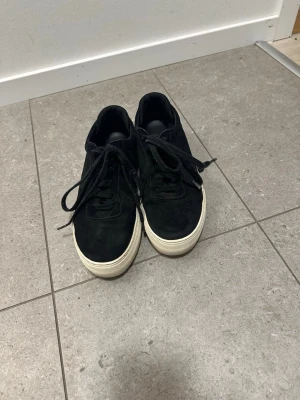 Axel Arigato Skor - Ett par svarta Axel Arigato sneakers i mocka. Dom ser knappt ut att vara använda och det medföljer originalkartong. 