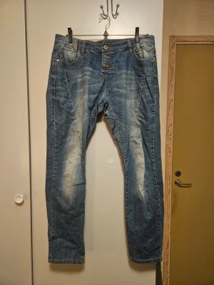 Vila Cila Boyfriend Jeans 30/34 - Blå boyfriend jeans från Vila i modellen Cila. Jeansen har en avslappnad passform, knappar i gylfen och klassiska fem fickor. Materialet är jeans med snygga slitningar och ljusare partier framtill för en cool look.