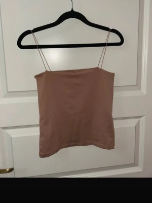 Beige linnetopp från Amisu - Säljer en enkel och stilren beige linnetopp från Amisu i storlek XS. Toppen har tunna axelband och rak passform, perfekt till sommaren. Materialet känns mjukt och lätt mot huden.