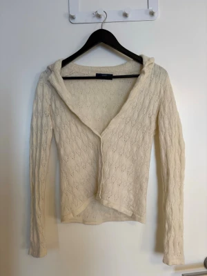 Dam krämvit kashmirkofta  - Superskön krämvit kofta i kashmir från GOBI. Koftan har ett diskret diamantmönster, lång är sopassning och en mjuk huva. I storlek XL men väldigt liten i storleken så passar mer som XS/S. Har ett hål som ni ser på sista bilden. 